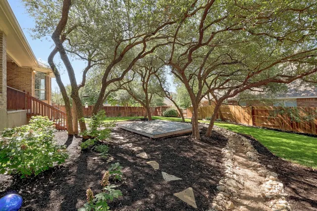 a view of a backyard with large trees