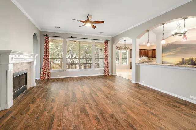 a view of a kitchen with furniture a ceiling fan and wooden floor