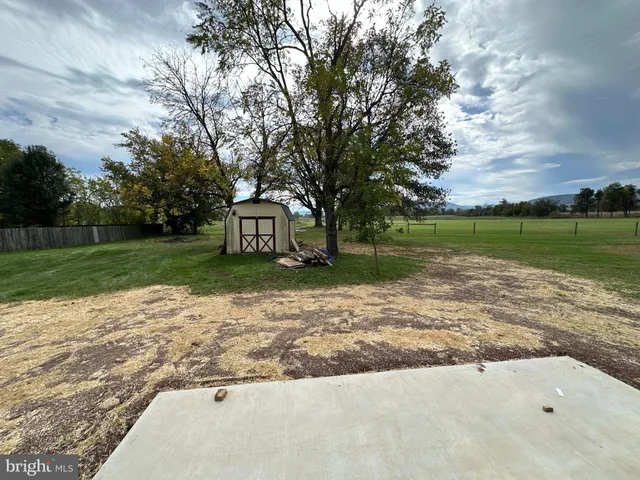 a kitchen with stainless steel appliances granite countertop a refrigerator a sink a stove with wooden cabinets and floors