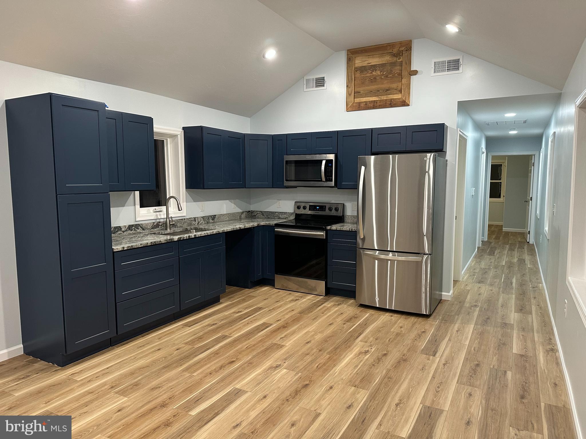 40 Mt Hope Road Fairfield, PA 17320 - Photo 6 of 13 a kitchen with stainless steel appliances granite countertop a refrigerator a sink a stove with wooden cabinets and floors