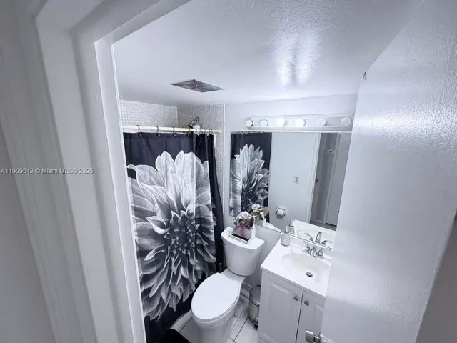 a bathroom with a sink and mirror with toilet
