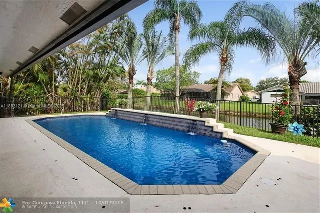 a view of swimming pool with a patio and a yard