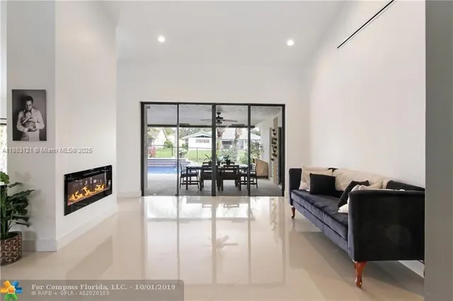 a living room with fireplace furniture and floor to ceiling window