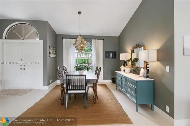 a dining room with furniture a chandelier and wooden floor