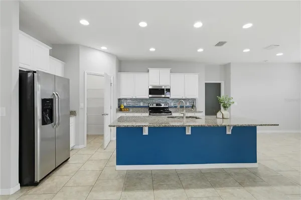 a kitchen with stainless steel appliances granite countertop a refrigerator and a sink