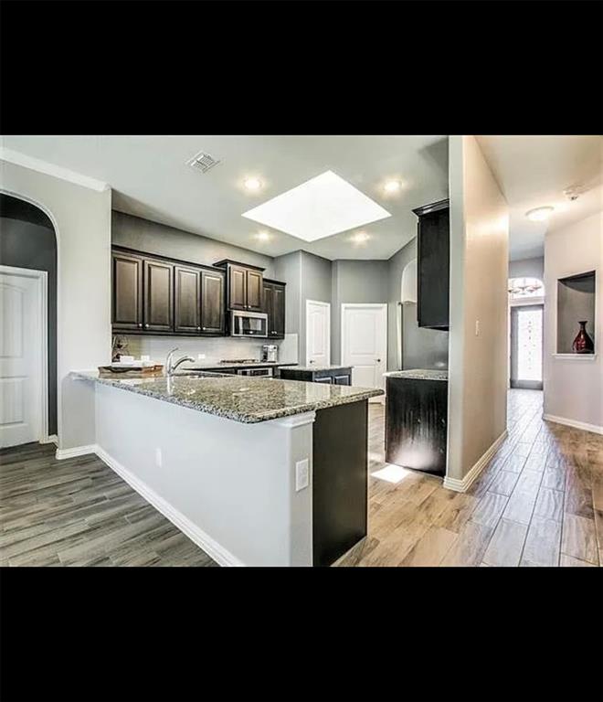 3905 Gennaker Drive Denton, TX 76210 - Photo 4 of 13 a view of kitchen with granite countertop microwave oven and white cabinets