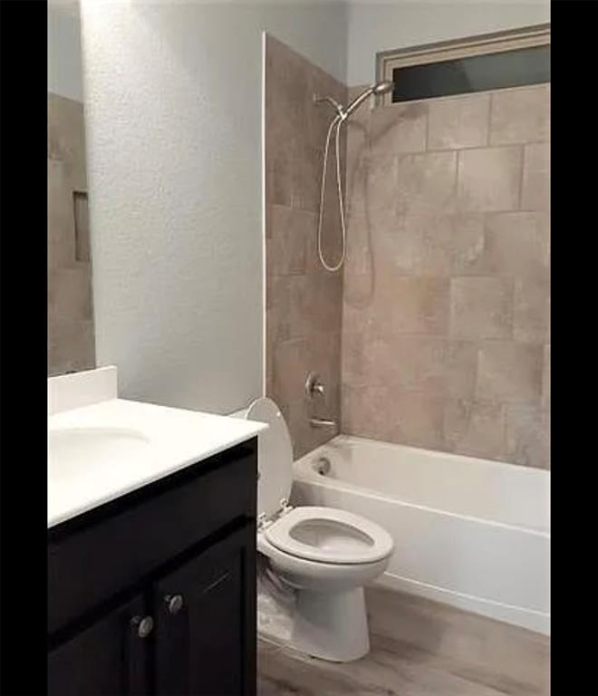 3905 Gennaker Drive Denton, TX 76210 - Photo 6 of 13 a bathroom with a bathtub shower sink vanity and toilet
