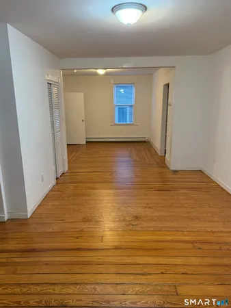a view of empty room with wooden floor