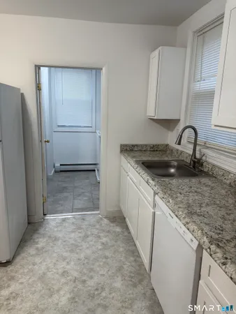 a kitchen with stainless steel appliances granite countertop a sink and a refrigerator