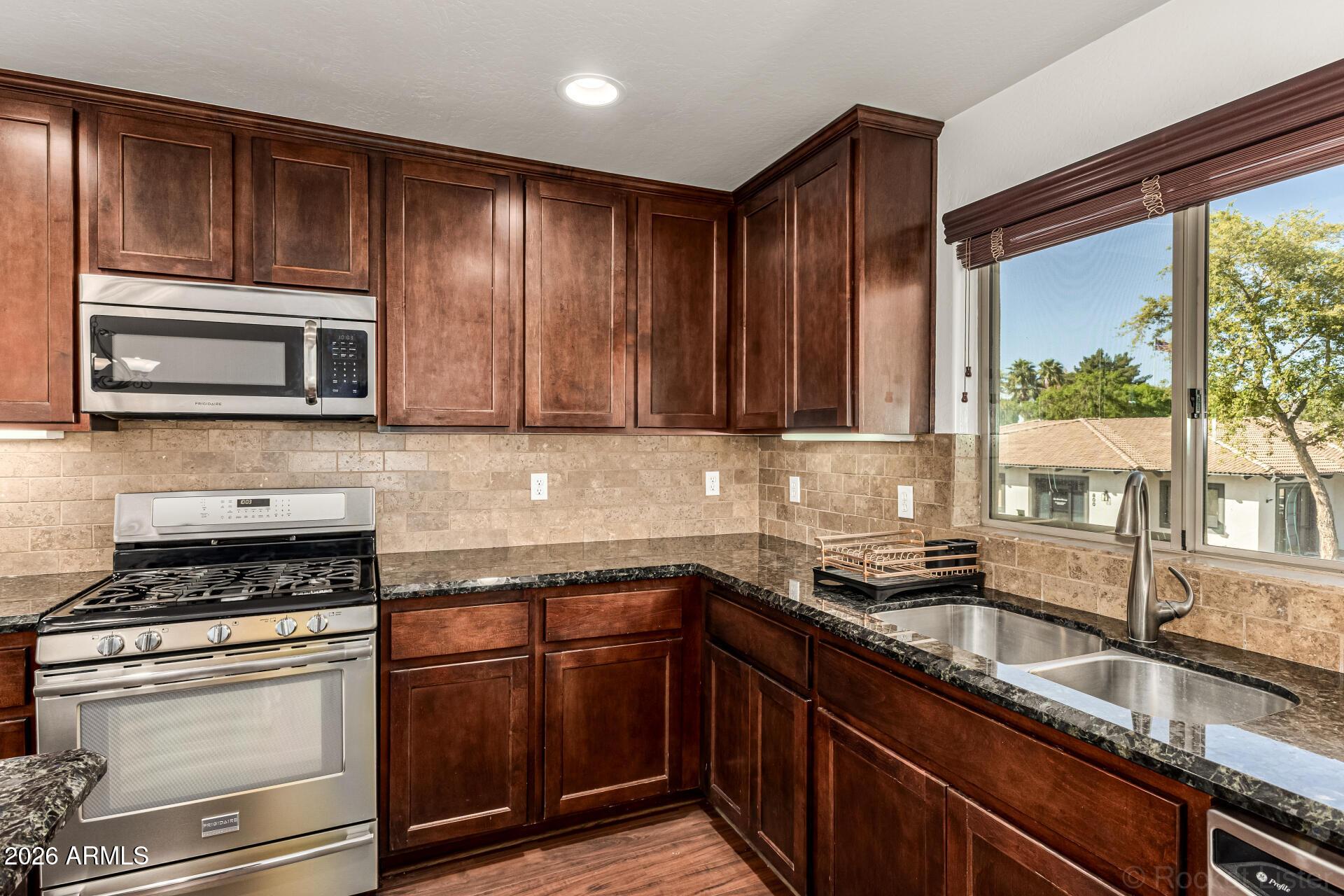 6940 East Cochise Road, Unit 1043 Paradise Valley, AZ 85253 - Photo 14 of 35 a kitchen with granite countertop cabinets stainless steel appliances a sink and window