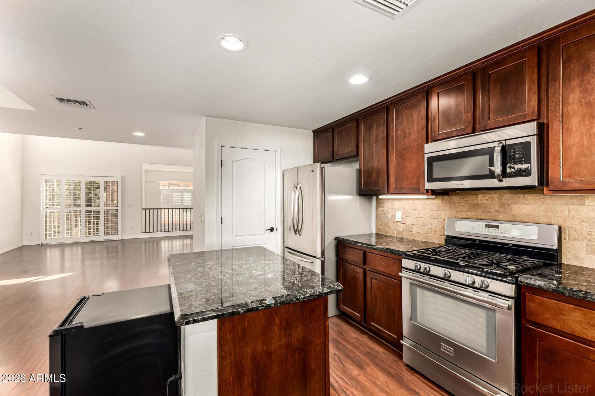 6940 East Cochise Road, Unit 1043 Paradise Valley, AZ 85253 - Photo 15 of 35 a kitchen with stainless steel appliances granite countertop a stove refrigerator and microwave