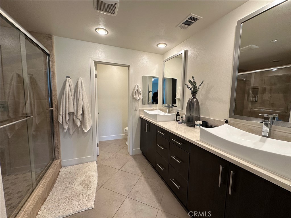 61 Gramercy Irvine, CA 92612 - Photo 13 of 33 a bathroom with a double vanity sink a toilet and a mirror