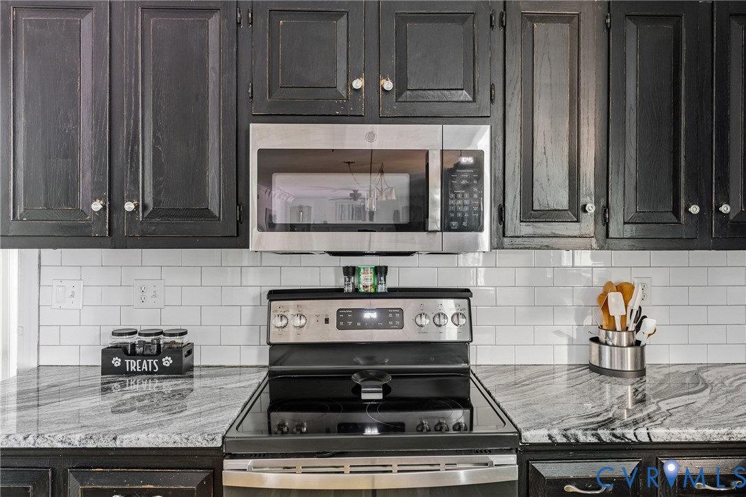 14321 Crossings Ridge Drive Midlothian, VA 23113 - Photo 15 of 43 a kitchen with granite countertop a stove a microwave and oven with wooden cabinets