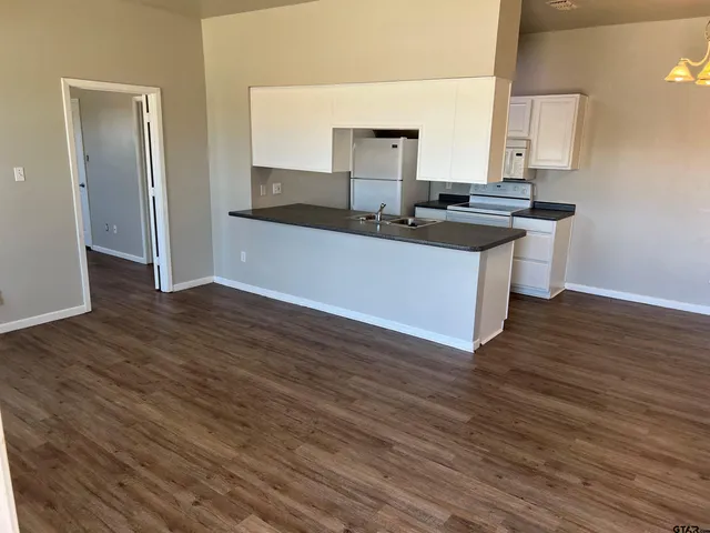 a kitchen with granite countertop a sink and a stove top oven