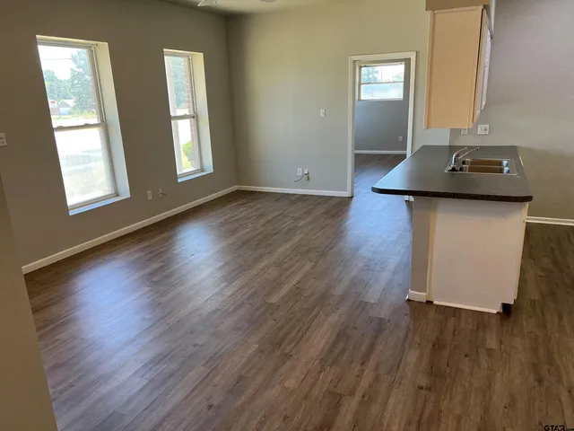 a room with wooden floor and white walls