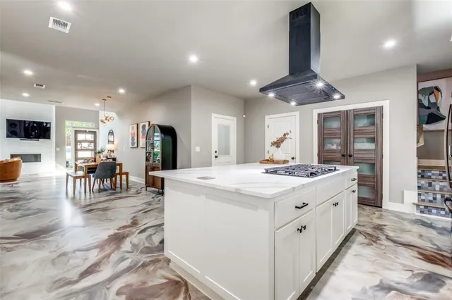 a kitchen with stainless steel appliances kitchen island granite countertop a stove and a refrigerator