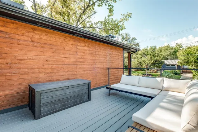 a backyard of a house with wooden floor and outdoor seating
