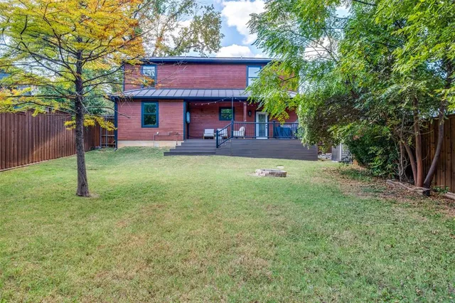 a view of a house with a yard porch and tree