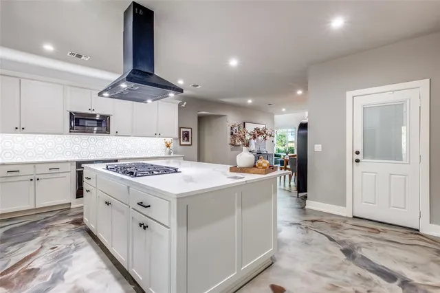 a kitchen with kitchen island a stove a sink a refrigerator and chairs