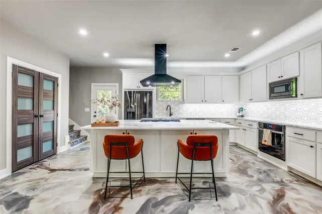 a kitchen with stainless steel appliances granite countertop a stove a sink a oven a dining table and chairs