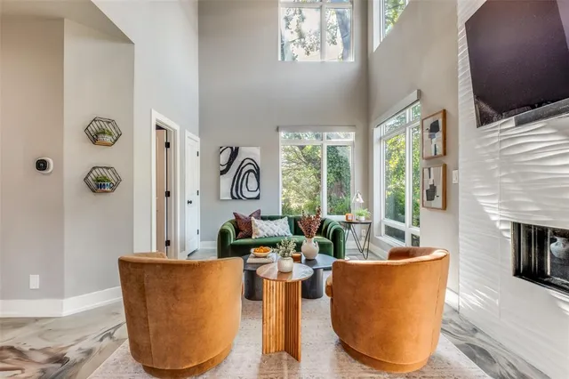 a living room with furniture a large window and a fireplace