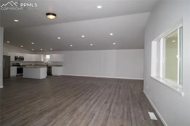 a large kitchen with granite countertop a large counter top appliances and cabinets