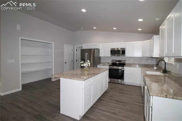 a kitchen with a refrigerator and white cabinets