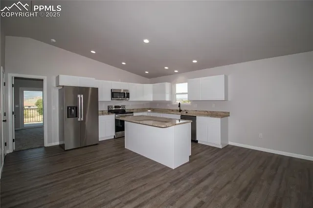 a kitchen with a refrigerator and white cabinets