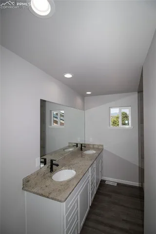 a bathroom with a granite countertop sink and a mirror