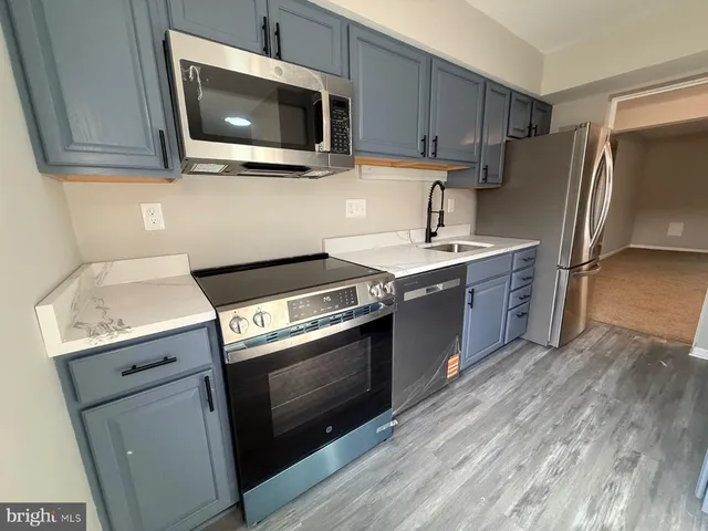 a kitchen with stainless steel appliances a stove microwave and sink