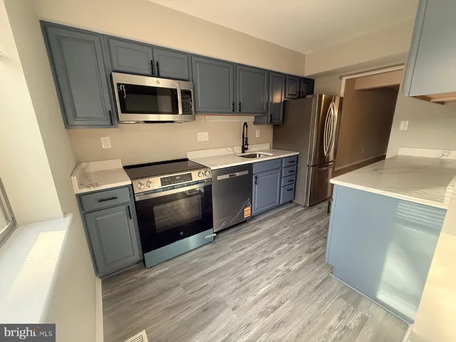 a kitchen with a sink stainless steel appliances and cabinets
