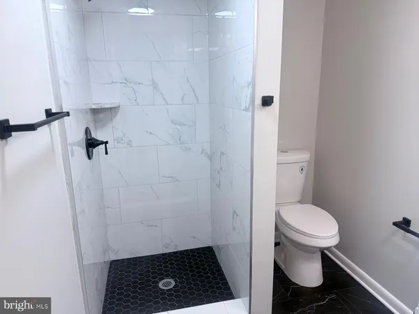 a bathroom with a toilet and a shower