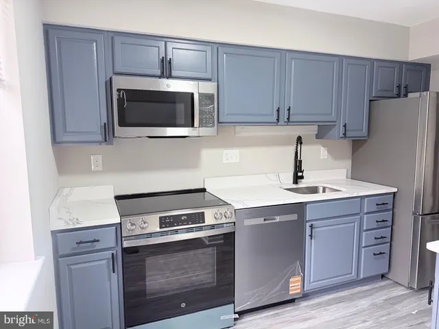 a kitchen with cabinets stainless steel appliances and a sink