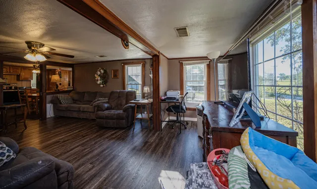 a living room with furniture a wooden floor and a large window