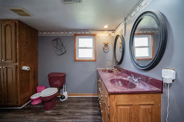 a bathroom with a toilet mirror vanity and toilet