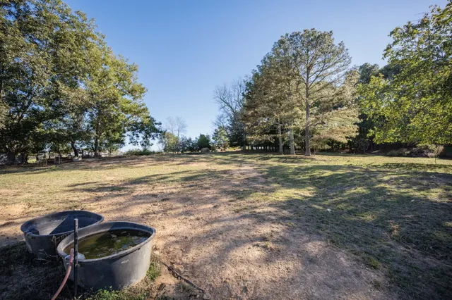 a view of a backyard with table and chairs under an umbrella