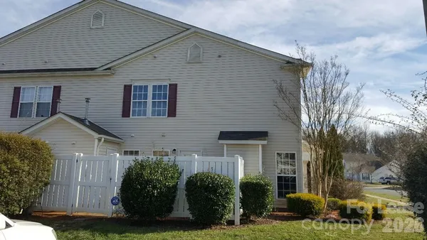 a view of a white house next to a yard
