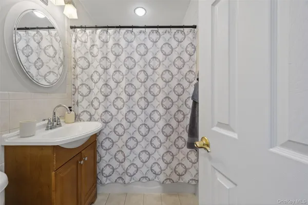 a view of a hallway with a livingroom and a bathroom with a sink