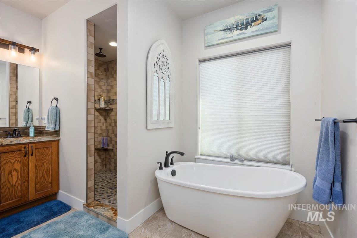 40 Bell Rapids Road Hagerman, ID 83332 - Photo 23 of 50 Full bath with walk in shower, a freestanding bath, and vanity