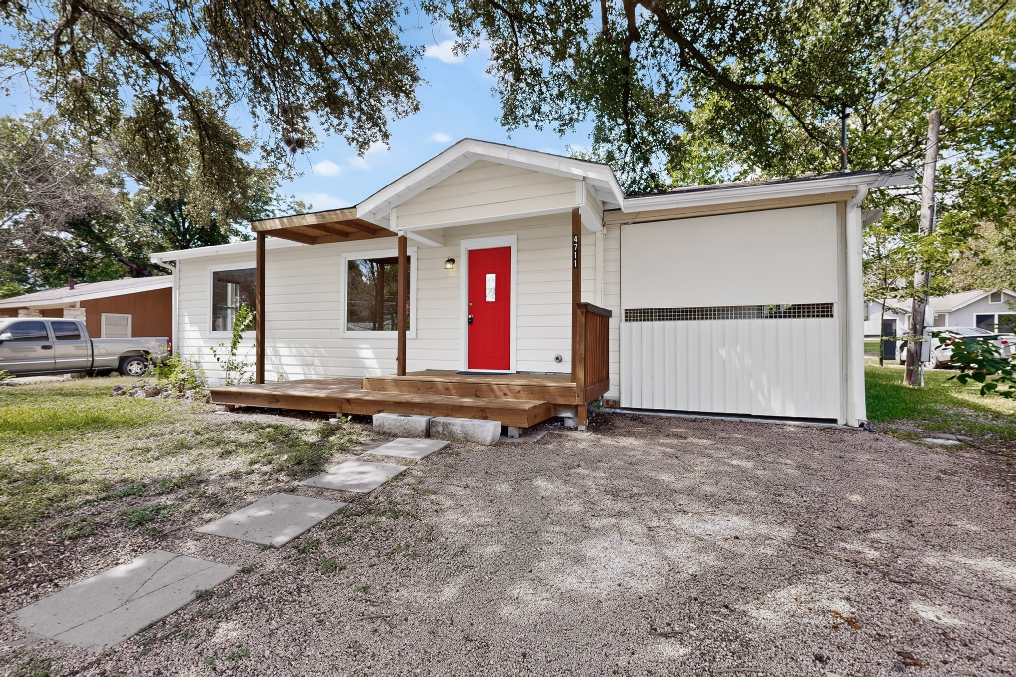 4711 Alf Avenue Austin, TX 78721 - Photo 3 of 34 A charming exterior with a vivid red entry door and a spacious garage, ready to welcome you home.