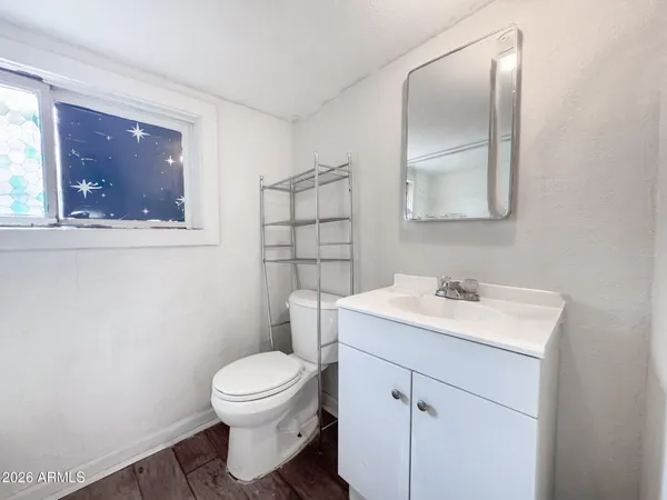 a bathroom with a toilet a sink and mirror