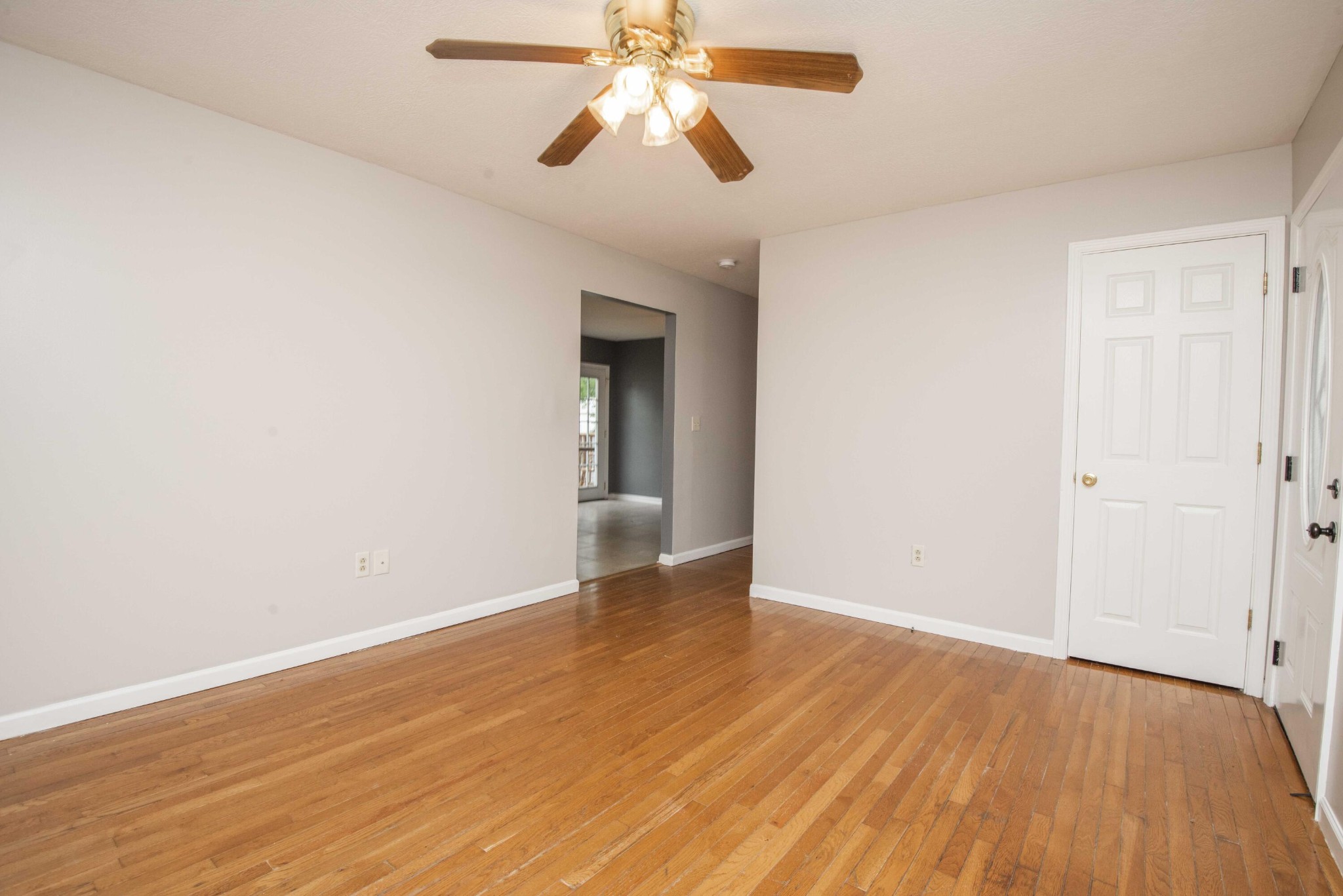 107 East Arrowwood Road Oak Ridge, TN 37830 - Photo 8 of 25 an empty room with wooden floor chandelier fan and windows