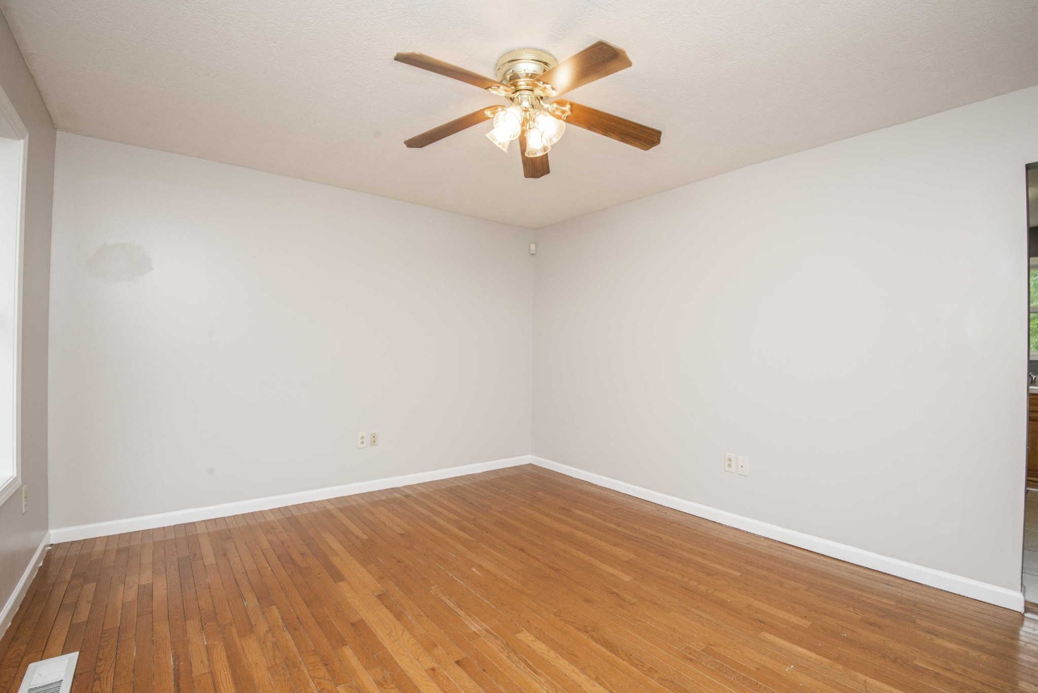 107 East Arrowwood Road Oak Ridge, TN 37830 - Photo 9 of 25 an empty room with wooden floor and a ceiling fan