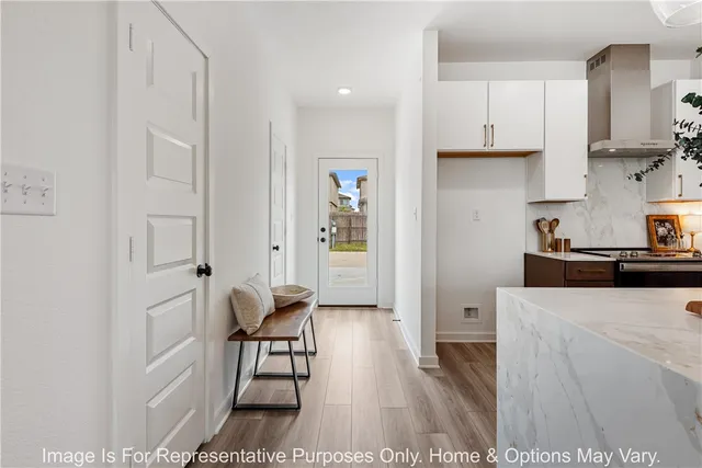 a living room with stainless steel appliances furniture a refrigerator and a cabinets