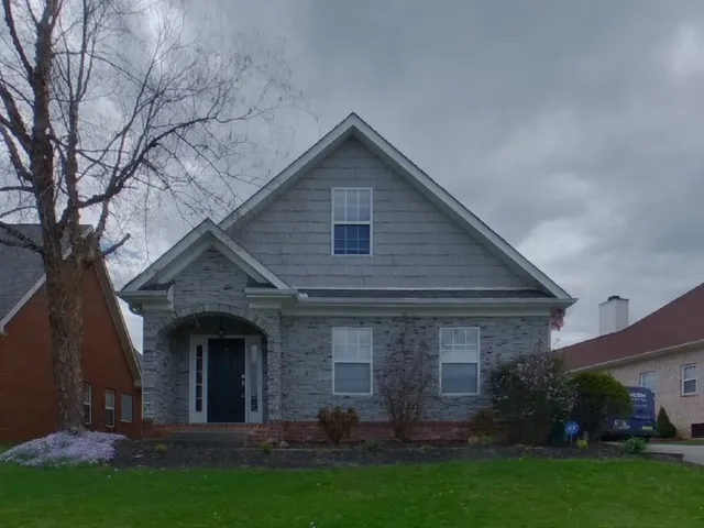 a front view of house with a garden
