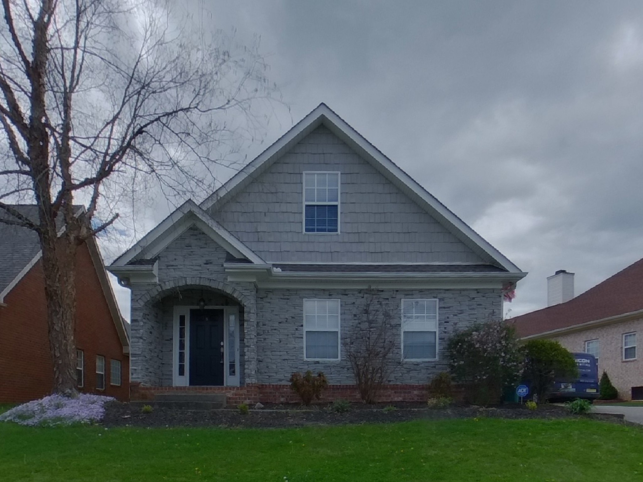 a front view of house with a garden