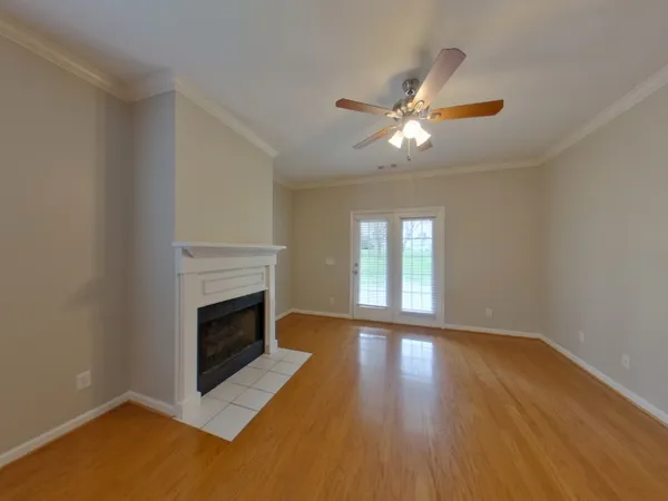 a view of empty room with wooden floor and fireplace