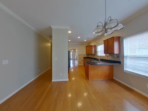 a view of kitchen with kitchen island granite countertop a stove top oven a sink a counter space and cabinets