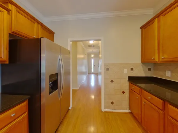 a kitchen with stainless steel appliances granite countertop a refrigerator and a stove