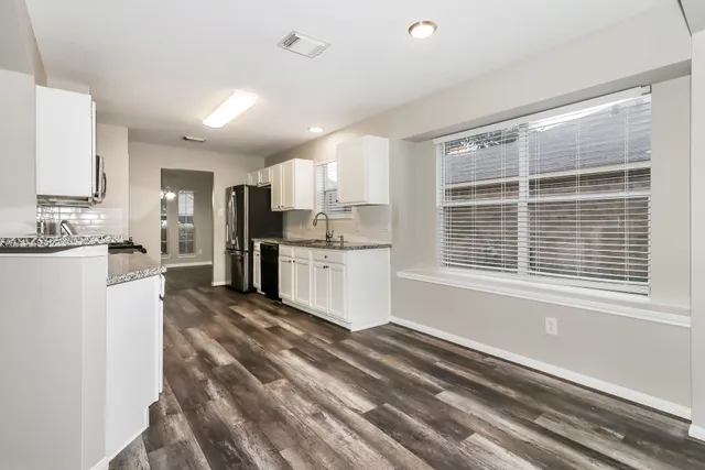a large white kitchen with cabinets